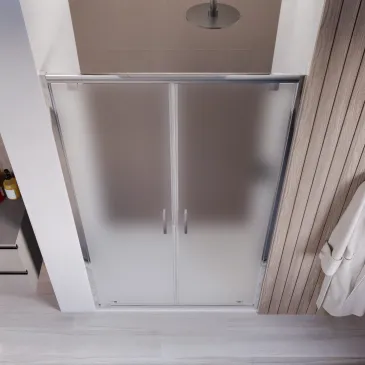 Installazione a nicchia della porta doccia saloon con profili in alluminio cromato e vetri satinati.